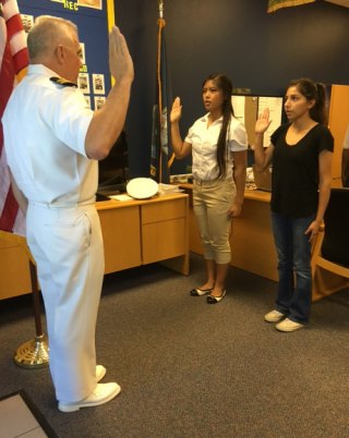 Lemoore High School NJROTC Instructor Lt. Cmdr. John Wolstenholme swears Jackylyn Domingo into the Navy.
